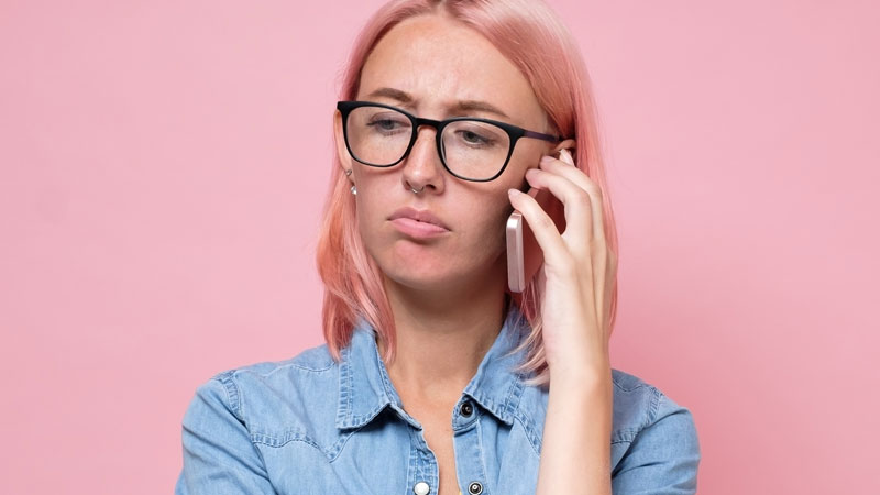 Mulher ao telemóvel com cara pouco satisfeita